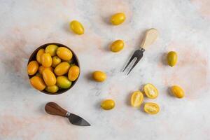 Top view of kumquats in the bowl and on ground photo