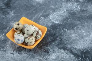 Close up photo of organic quail eggs in yellow bowl
