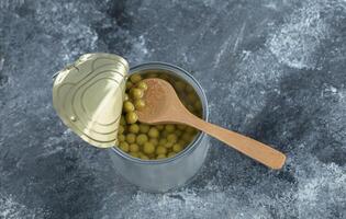 Top view of canned olive in ti over grey background photo