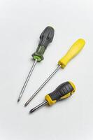 Different old screwdrivers on a white background. Cross, minus and with a rubber handle against electric shock. High quality photo