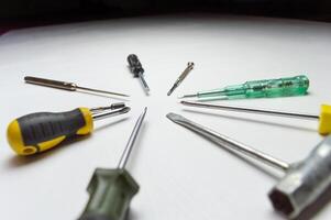 Different old screwdrivers on a white background. Cross, minus and with a rubber handle against electric shock. High quality photo