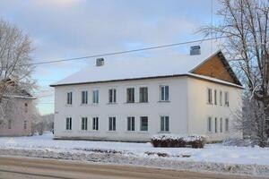 A Beautiful SnowCovered White Building Set in a Serene Winter Landscape and Scene photo