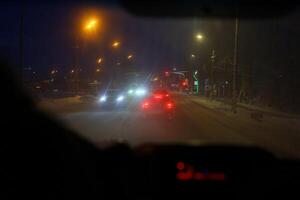Experiencing the mesmerizing beauty of nighttime city driving in snowy weather conditions photo