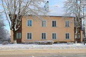 A beautiful winter landscape depicting a snowcovered building surrounded by serene trees photo