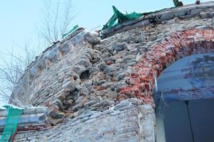 Weathered Stone Wall featuring an Archway along with Various Renovation Materials nearby photo