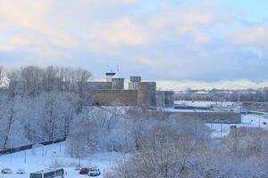 A winter scene shows a historic fortress surrounded by snow, creating a serene atmosphere photo
