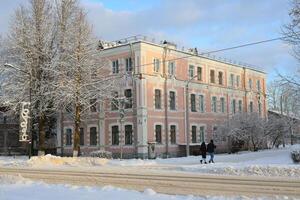 A picturesque winter scene featuring a charming historical pink building amidst a snowy landscape photo
