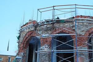The restoration work of a historic brick building is currently underway and is under construction photo