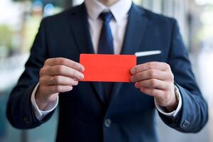 Man in suit holds vibrant red ticket, emphasizing its bold contrast photo