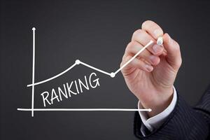 Suited hand draws upward ranking line, symbolizing growth and performance photo