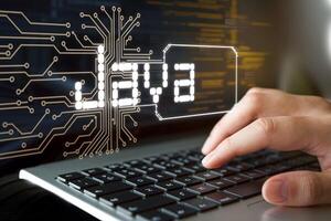 JAVA text with circuitry and hand typing, emphasizing software development theme photo