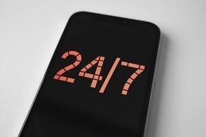 Smartphone displays 24 7 service on clean white background for simplicity photo