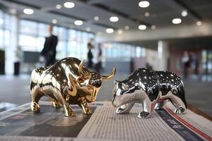 Golden bull and silver bear figurines rest on a newspaper, symbolizing markets photo