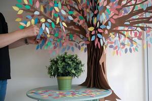un vibrante papel árbol adornado con vistoso hojas, con un tranquilo verde planta abajo foto
