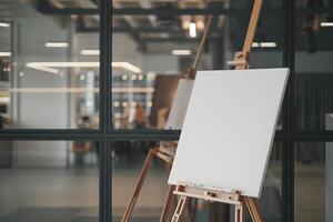 Blank Canvas on Wooden Easel Reflecting Indoor Depth and Glass Partition photo