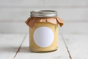 Glass Jar with Yellow Preserve Rustic glass jar with yellow preserve on simple white surface photo