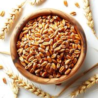 Ears of wheat in a wooden bowl on a white background, top view photo