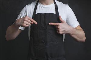 White T shirt, black apron, practical design emphasized against dark simple background photo