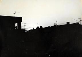 A black and white photo of a building with a sky in the background