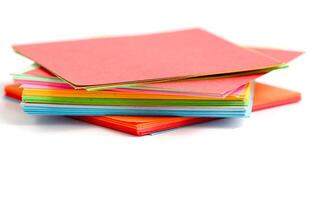 A stack of colorful paper on a white background photo