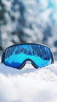 Winter Ski Goggles Reflecting Snowy Mountain Scenery photo