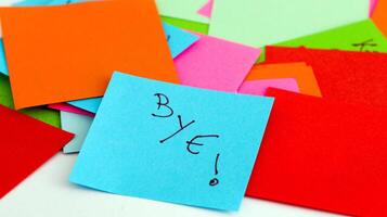 A pile of colorful post-it notes with the word bye written on them photo