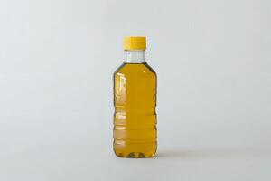 A Clear Plastic Bottle Filled with Golden Yellow Cooking Oil, Sealed with a Yellow Cap, Stands Against a Plain White Background. A Guide to Culinary Oils and Their Uses in the Kitchen photo