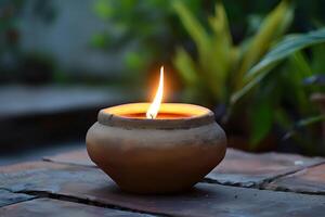 A Glowing Candle Flame Illuminates a Rustic Clay Pot at Dusk, Creating a Serene and Tranquil Atmosphere. Symbol of Peace and Reflection in Nature's Embrace. photo