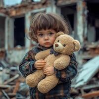 Young child holding teddy bear in front of ruined building with debris scattered on the ground after a disaster photo