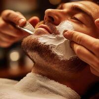 Skilled barber performing a traditional shave on a client in a cozy barbershop during the evening photo