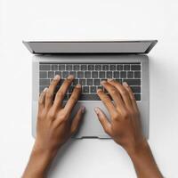 Hands typing on a laptop keyboard on a white surface in a bright workspace photo