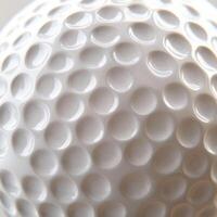 Close-up view of a textured golf ball highlighting dimples and surface details in natural light photo