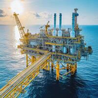 Oil rig platform in the ocean during sunset with vibrant colors and active machinery photo