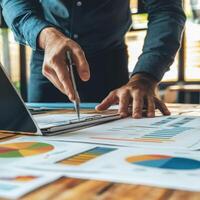 Professional preparing a business report with charts and graphs in a modern office setting photo
