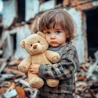 Young child holds teddy bear in front of collapsed building ruins in a desolate area affected by disaster photo