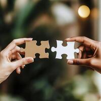 Two hands holding puzzle pieces representing connection and collaboration in a natural setting photo