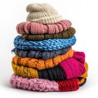 Colorful stack of knitted hats displayed on a white background showcasing winter fashion accessories photo