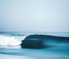 Surfing wave breaks along a calm shore under clear skies during early morning light photo