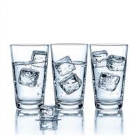 Refreshing cold water with ice cubes served in three glasses on a white background photo