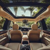 Luxurious interior view of a modern SUV parked in a tropical setting with lush greenery and sunlight streaming through the sunroof photo
