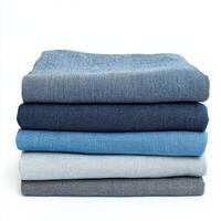 Stacked fabric pieces in varying shades of blue and gray on a white background showcase textures and colors photo