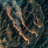 Fire spreads across mountainous terrain during a dry summer, causing damage and threatening local wildlife in California photo