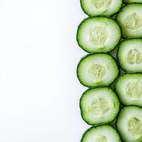 Freshly sliced cucumber arranged neatly on a white background enjoy healthy eating and vibrant colors photo