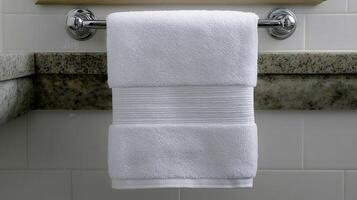 Luxurious white towel neatly displayed on a chrome rack in a sleek, contemporary bathroom decor photo