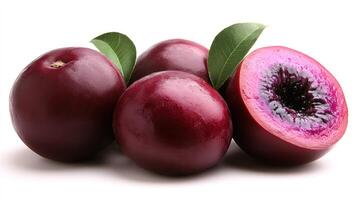 Fresh, dark purple plums are arranged with one sliced open, showcasing their vibrant interior photo