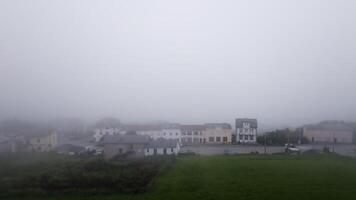 Fog envelops buildings on a cloudy day, creating a serene and atmospheric landscape filled with gray hues video