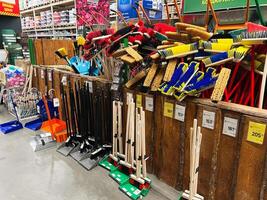 Kyiv, Ukraine - January 03, 2025 Organized display of colorful cleaning tools including brooms and dustpans in a store. photo