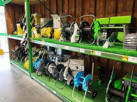 Kyiv, Ukraine - January 03, 2025 row of assorted hose reels displayed on store shelves in a hardware store photo