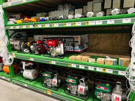 Kyiv, Ukraine - January 03, 2025 Row of water pumps and accessories displayed on store shelves photo