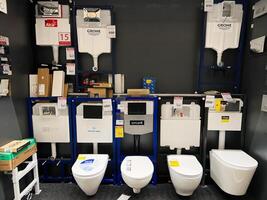 Kyiv, Ukraine - January 03, 2025 Modern toilet fixtures and flush tanks displayed on store shelves for selection photo